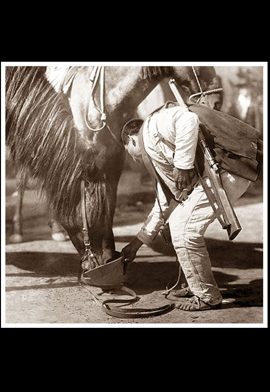 Soldado federal dando agua a su caballo con el casco